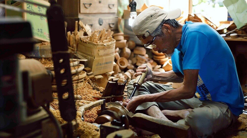 ろくろを使って木地を削り出していく職人。自宅の工房で作業するのも輪島塗の特徴だ